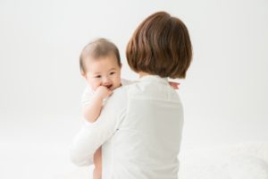 子供を抱く女性の後ろ姿