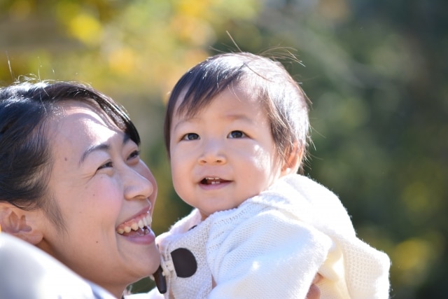 笑顔で子供と遊ぶ若い母親